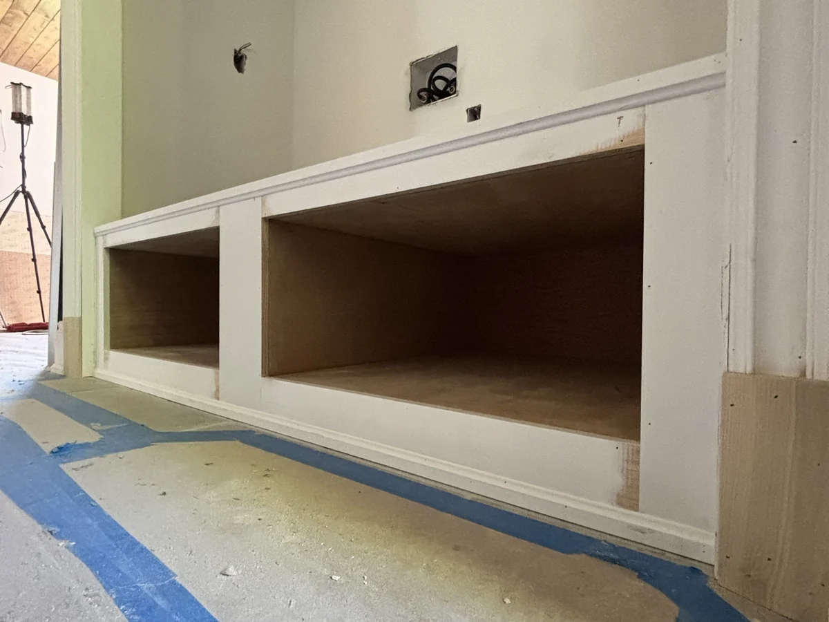 Painted built-in bench with two open cubbies, fitted between door casings