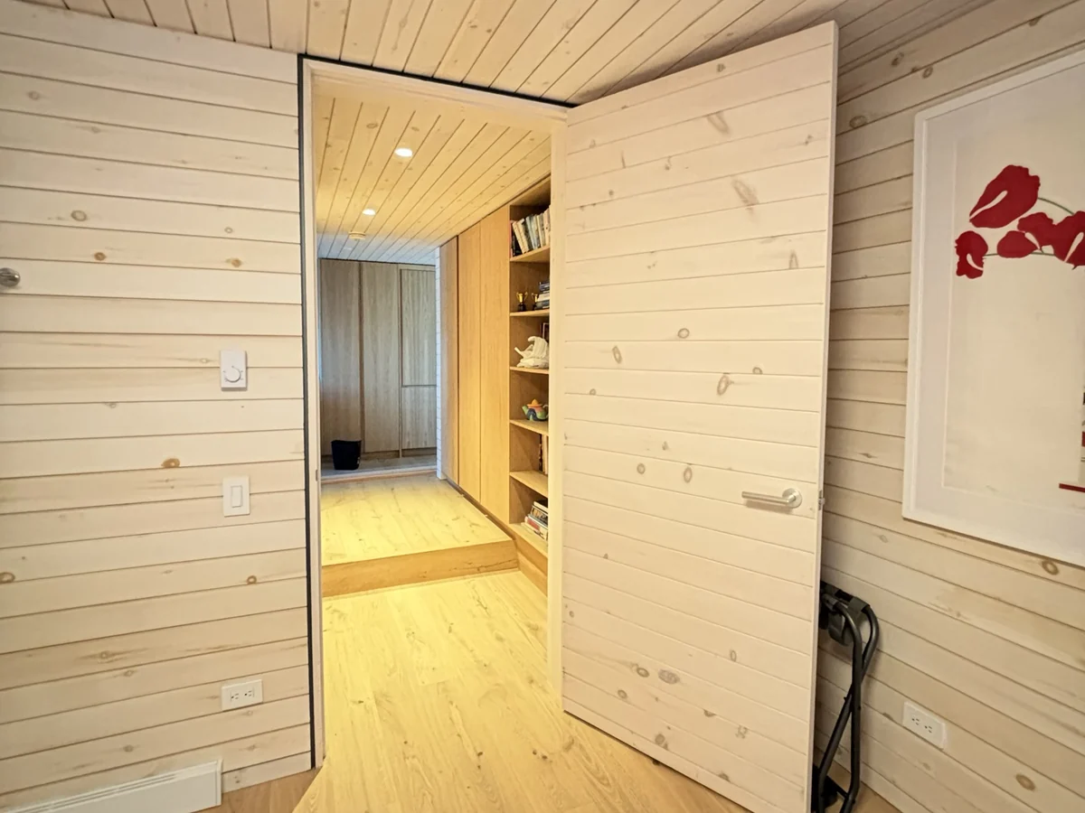 Flush pine-panelled door set into a matching horizontal pine wall